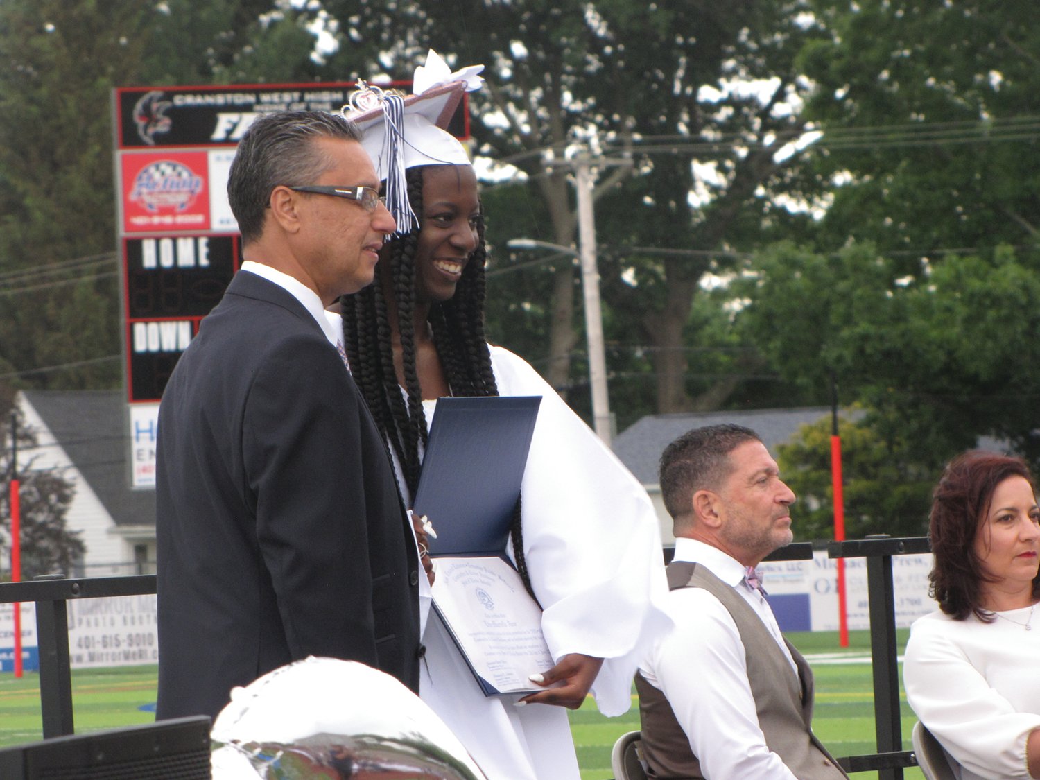 CAPTURING THE MOMENT: Litz-Murielle Azor poses with NEL/CPS Executive Director
Ramon Torres after receiving her diploma Friday. (Herald photos by Daniel Kittredge